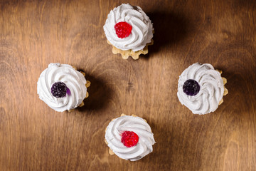 Airy protein pastry basket with red raspberry on wooden table . flat lay