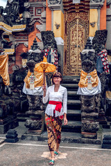 European young woman in balinese traditional temple. Bali island.