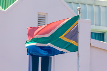 Flag of South Africa and traditional white building background
