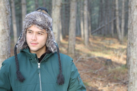 Ethnic man with winter hat in the forest