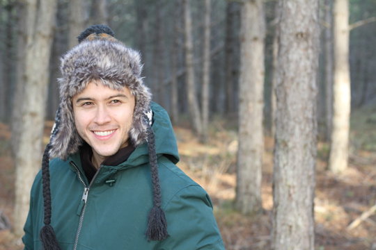 Ethnic man with winter hat in the forest 
