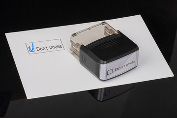 Don't smoke - checkbox with a tick on white paper with handle Rubber Stamper. Checklist concept.