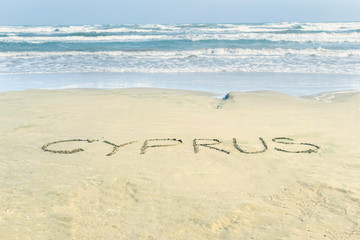 Word Cyprus on the wet sandy Mackenzie beach in Larnaca.  Name country text. Concept.