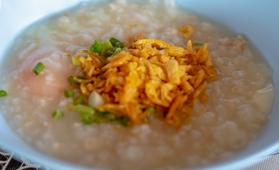 Mush and top with deep fried garlic, boiled egg and vegetable, breakfast of Thai food.