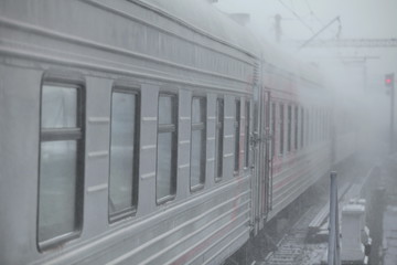 winter railway, train passes by in the snowy distance