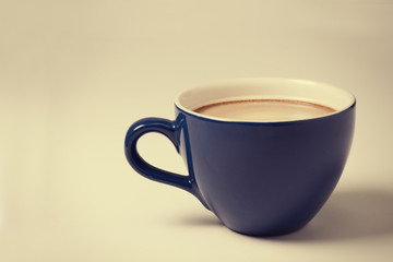 A cup on a table. A toned picture.