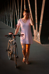 Fototapeta na wymiar Young woman with bike in urban scenery