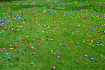 An Easter egg hunt with colorful plastic eggs on a green lawn