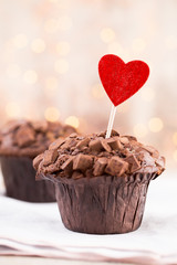 Homemade chocolate muffins with heart, vintage background.