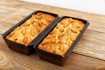 Two freshly made homemade almond cakes on wooden table. Shallow focus.