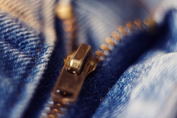 zipper made of brass on the rough blue jeans fastened