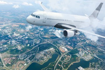 Plane flying sky. Airplane above city. White passenger aircraft climbs through the clouds. Planes...