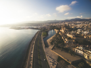 Aerial drone view Majorca cityscape, road along the coast of mediterranean sea and famous Cathedral of Palma de Mallorca or Le Seu. Balearic islands. Spain