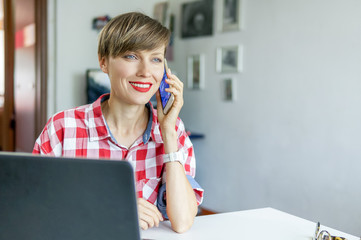 Young woman in office talking on phone