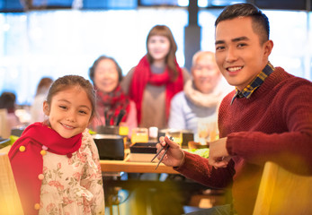 happy asian family having dinner at restaurant