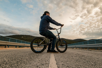 BMX rider with his bmx bike on the street. Guy riding in bmx