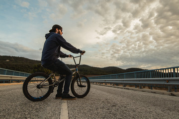 BMX rider with his bmx bike on the street. Guy riding in bmx