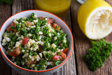 Tabbouleh salad with bulgur, fresh parsley, tomatoes and  salad  dressing