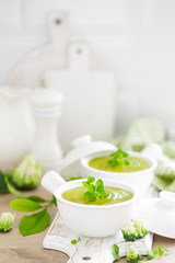 Obraz na płótnie Canvas Broccoli soup in bowls on wooden kitchen table closeup. Healthy vegetarian dish. Diet food