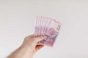 money of Ukrainian hryvnias in male hands.