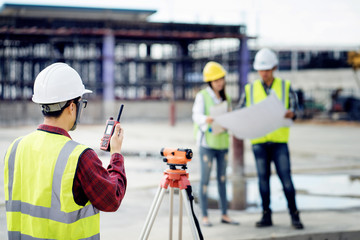 surveyor engineer with theodolite at construction site during surveying work.engineer and architect...