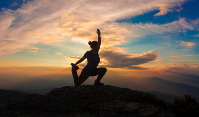 girl or woman silhouette posing in sunset mountain landscape. freedom and happiness concept