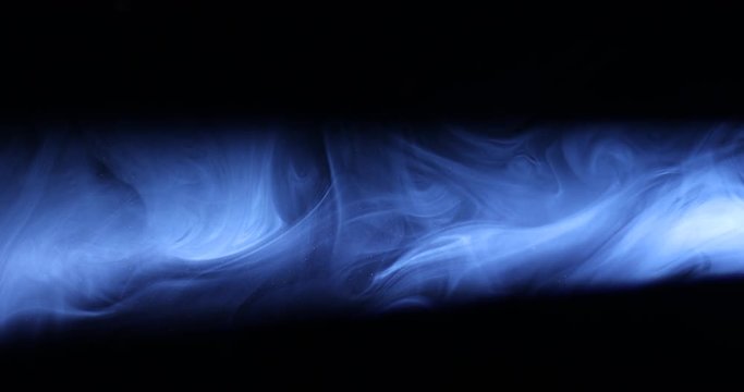 Smoke on black background in blue light