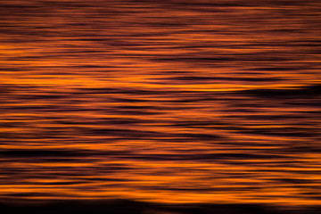 artistic image with blurry and stretched ocean red water in long exposure with movement - perfect background for water and sunset concept