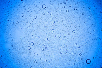 Rain droplets on blue glass background, Water drops on blue glass.