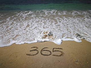 365 number written on sandy beach