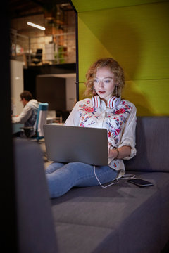 Young woman working in modern creative office, using laptop