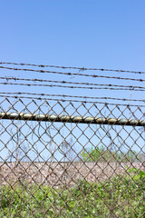 Chain link fence with barbed wire blue sky