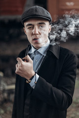 sherlock holmes look, man in retro outfit, smoking wooden pipe. england in 1920s theme. fashionable...