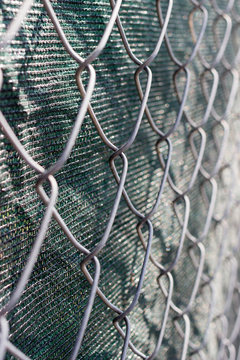 Close up of chain link fence with green fabric