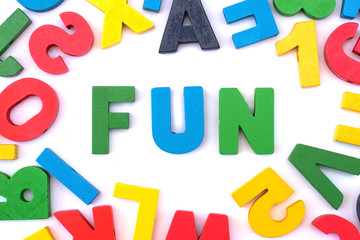 Many colorful wooden letters and word "Fun" on white background