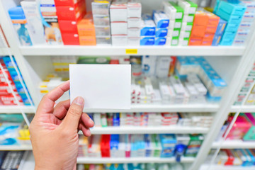 Hand with note pad on Shelves blurred in pharmacy store background