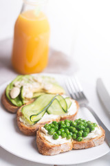 Set of green sandwiches prepared with different vegetables and bread. Tapas and orange juice on the napkin