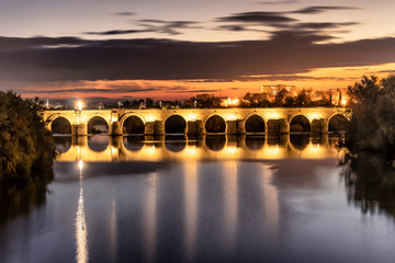 illuminated Roman bridge over  Guadalquivir river at evening in Cordoba, Andalusia, Spain