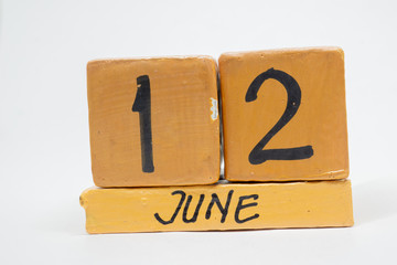june 12th. Day 12 of month, handmade wood calendar isolated on white background. summer month, day of the year concept