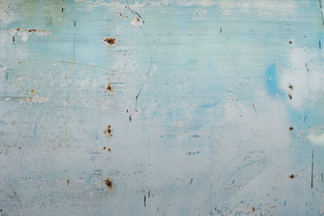 Rusty metal light blue garage wall with scratches