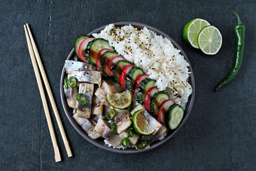 Poke a bowl of herring fillet, vegetables and rice.