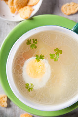 Top view on chicken broth with egg and crackers