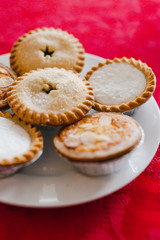 mince pies on Christmas table setting with with red cloth