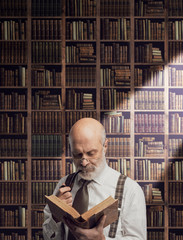 Academic professor in the library holding a book