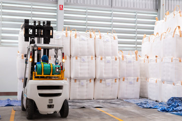 Forklift is handling jumbo bags in large warehouse for distribution to customer, import export...
