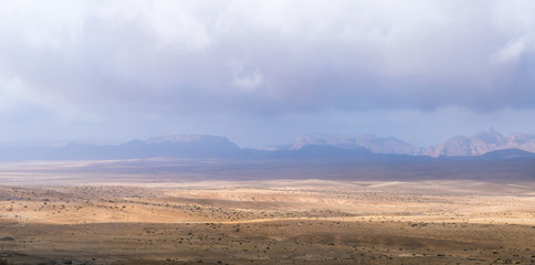 Fototapeta na wymiar Low dense fog falls on a stone desert in the south of Jordan