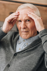 senior man with grey hair having headache