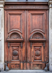 finely decorated wooden entrance door of an 18th century Milan palace, Italy
