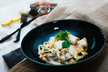 close-up of plate of pasta and chicken with lettuce