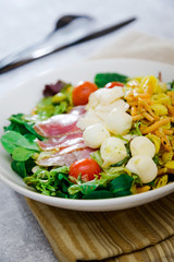 Salad with fusilli pasta accompanied tomatoes, mozzarella, smoked ham and italian cheese